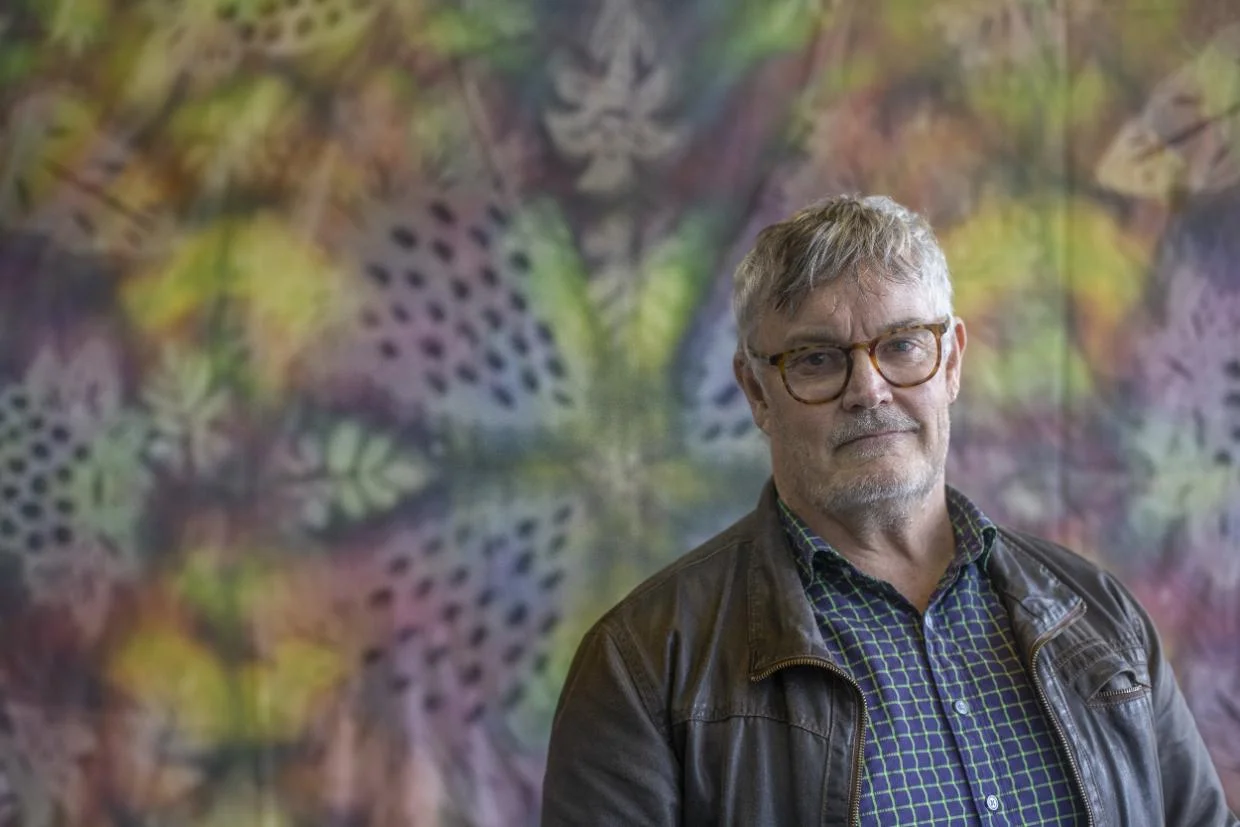 David Hanna, Director of Wesley Community Action in front of a patterned wall