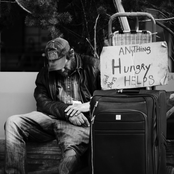 B&W homeless man with suitcase and sign