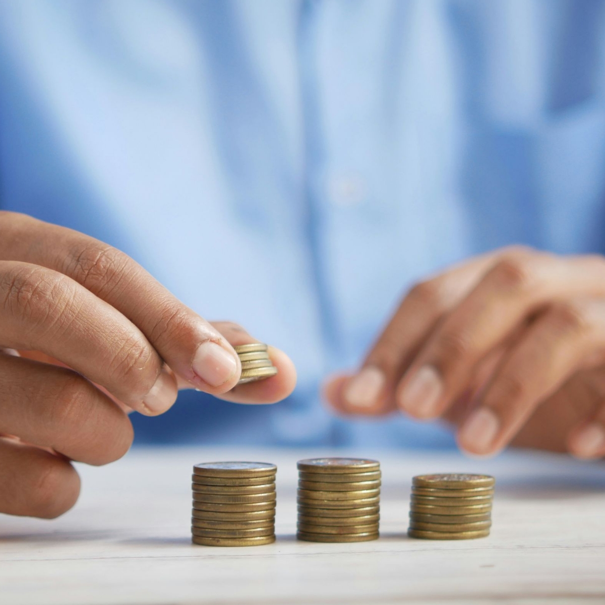 Person stacking coins on table