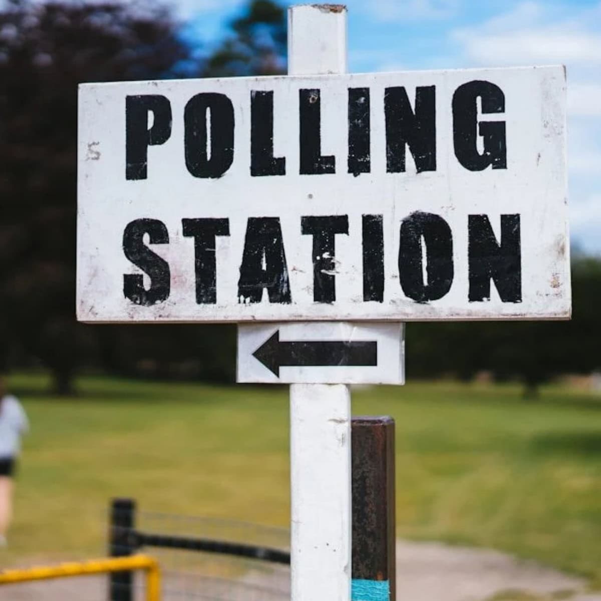 White sign pointing to polling station