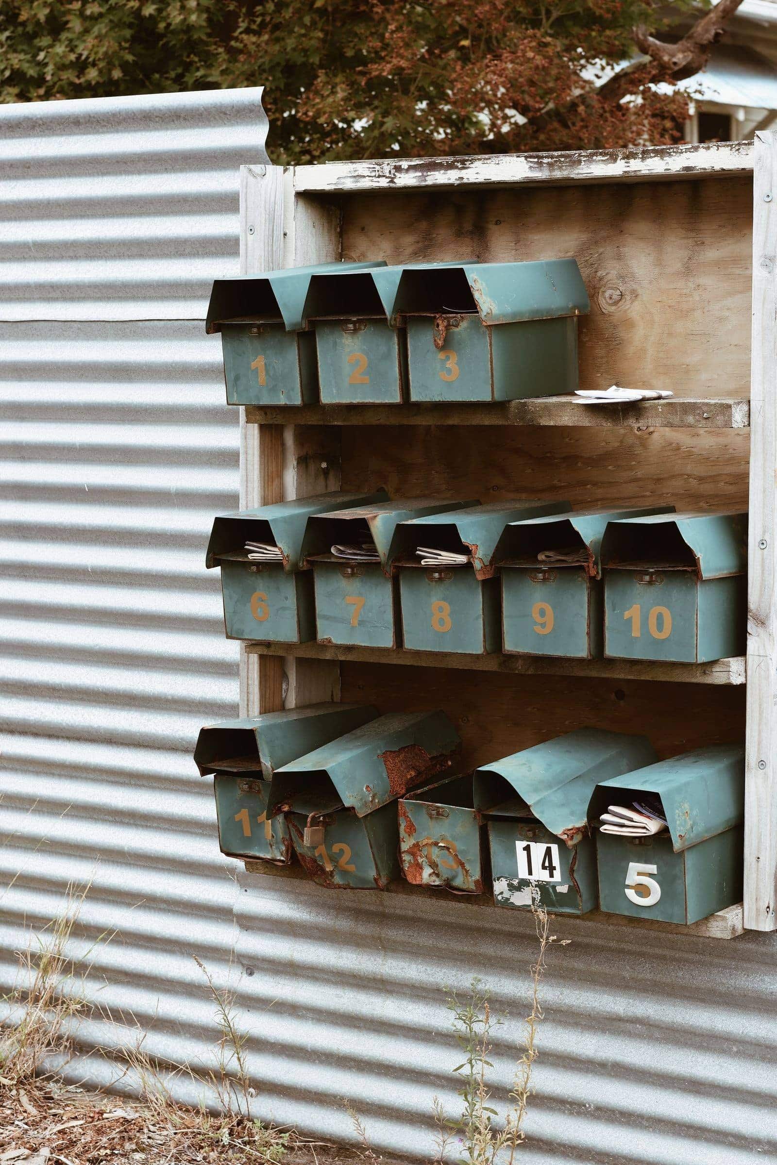 Rows of grey letter boxes on fence