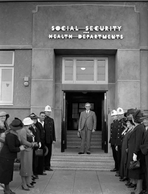 B&W - people outside Social security building, man on steps